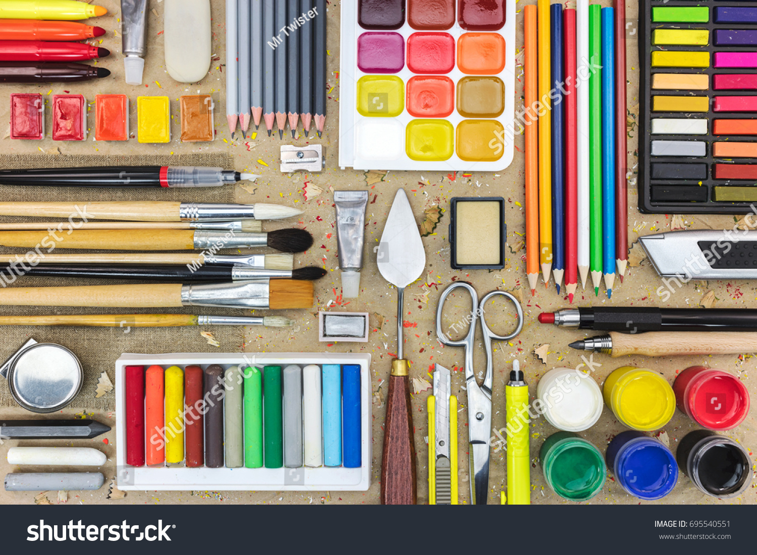 stock-photo-watercolor-paints-paintbrushes-for-painting-colored-pencils-pastel-crayons-and-other-on-desk-695540551.jpg
